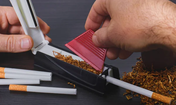 Man makes a cigarette, hands closeup — Stock Photo, Image