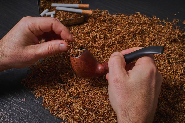 Man voert een pijp met tabak — Stockfoto
