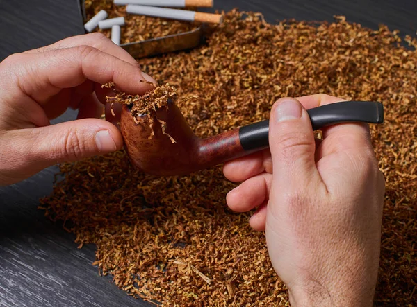 Man voert een pijp met tabak — Stockfoto