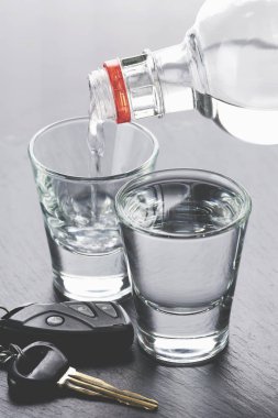 Bardaklara ve araba anahtarlarına alkol dökülüyor. 