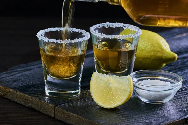 Strong alcoholic drink is poured into a glass — Stock Photo, Image