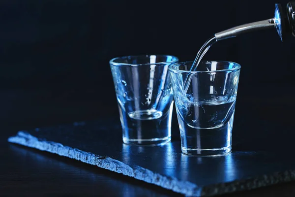 Flaska vodka hälls i ett glas — Stockfoto