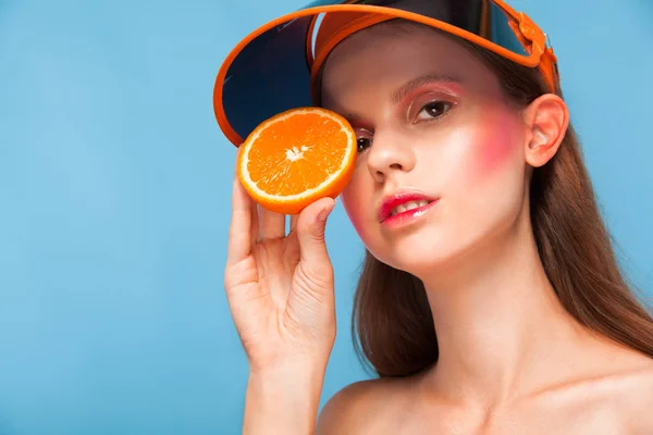 Joven mujer de moda con jugosa naranja sobre un fondo azul w —  Fotos de Stock