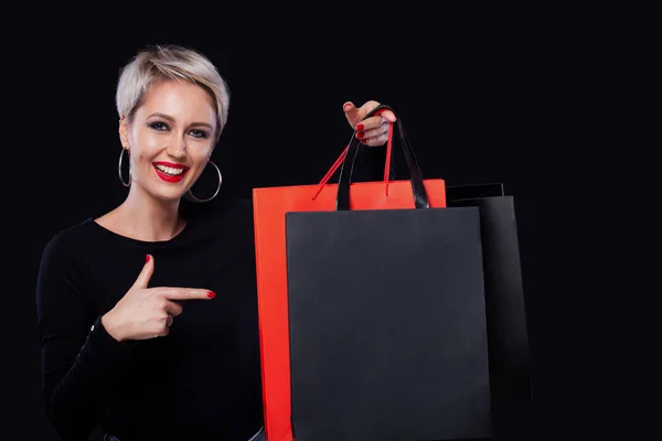 Shopping femme tenant des sacs de couleur isolés sur fond bleu en vacances noir vendredi. Concept de vente d'été . — Photo