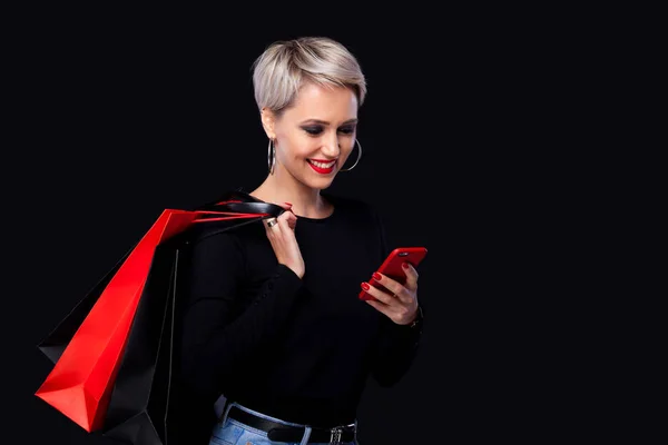 Mujer de compras sosteniendo bolsas de color aisladas sobre fondo azul en vacaciones de viernes negro. Concepto de venta verano . —  Fotos de Stock