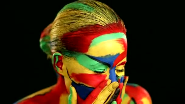 Kobieta z kolorowym malowaniem twarzy i ciała. Kolorowy portret dziewczyny z jasnym makijażem i body art. — Wideo stockowe
