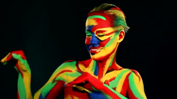 Kobieta tańczy z kolorową sztuką twarzy i farbą do ciała. Kolorowy portret dziewczyny z jasnym makijażem i body art. — Wideo stockowe