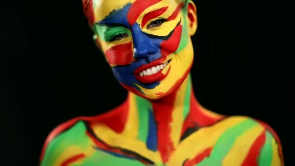 Mulher com arte facial colorida e pintura corporal. Retrato colorido da menina com maquiagem brilhante e bodyart. Movimento lento . — Vídeo de Stock