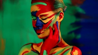 Renkli yüz ve vücut boyalı bir kadın. Parlak makyajlı ve vücut destekli kızın renkli portresi..