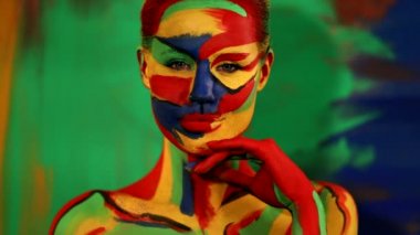 Renkli yüz ve vücut boyalı bir kadın. Parlak makyajlı ve vücut destekli kızın renkli portresi..