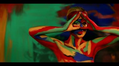 Renkli yüz ve vücut boyalı bir kadın. Parlak makyajlı ve vücut destekli kızın renkli portresi..