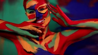 Renkli yüz ve vücut boyalı bir kadın. Parlak makyajlı ve vücut destekli kızın renkli portresi..