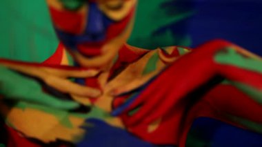 Renkli yüz ve vücut boyalı bir kadın. Parlak makyajlı ve vücut destekli kızın renkli portresi..