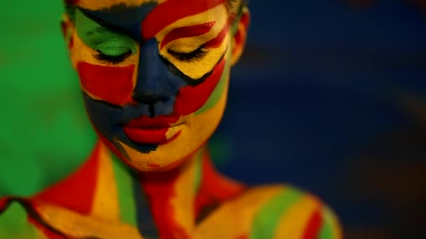 Renkli yüz ve vücut boyalı bir kadın. Parlak makyajlı ve vücut destekli kızın renkli portresi.. — Stok video