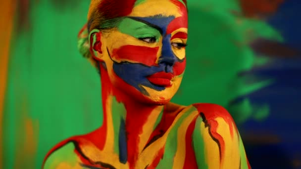 Kobieta z kolorowym malowaniem twarzy i ciała. Kolorowy portret dziewczyny z jasnym makijażem i body art. — Wideo stockowe