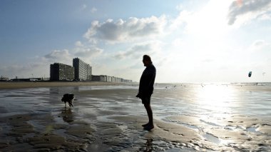 Ostend, Belçika - 9 Eylül 2014: Köpekle oynayan adam