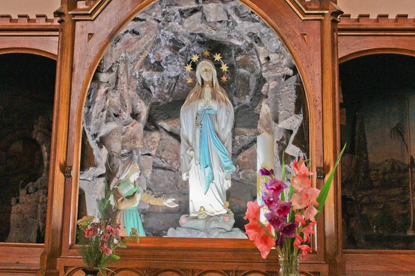 Church interior, detail to Madonna statue with flowers — Stock Photo, Image