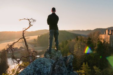 Genç adam kayanın üzerinde duruyor ve Divci Kamen 'i kayadan ayırmak istiyor. Çek Cumhuriyeti