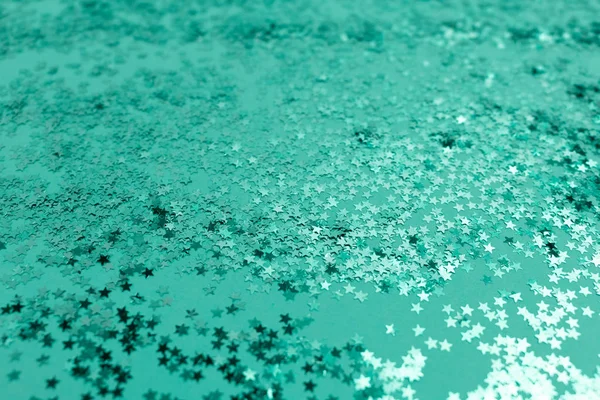 Texture made of stars glitter. Turquoise holidays background.