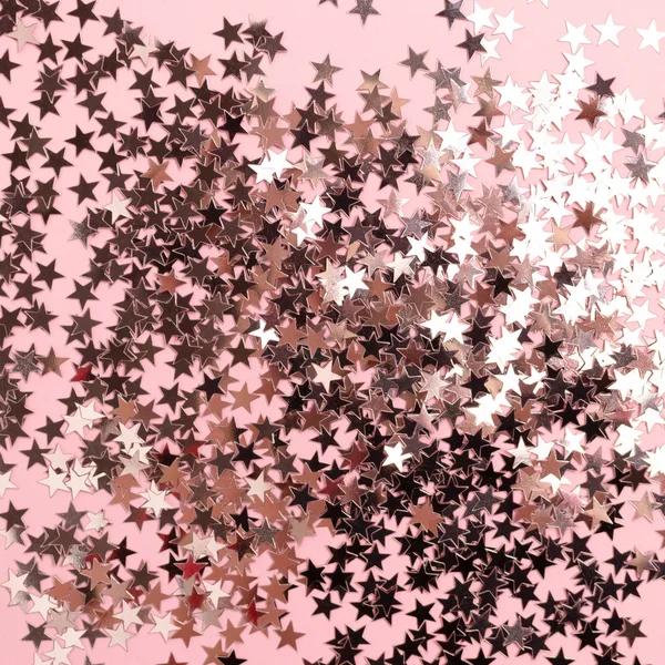 Texture of stars glitter on pink pastel background. Monochromatic concept.