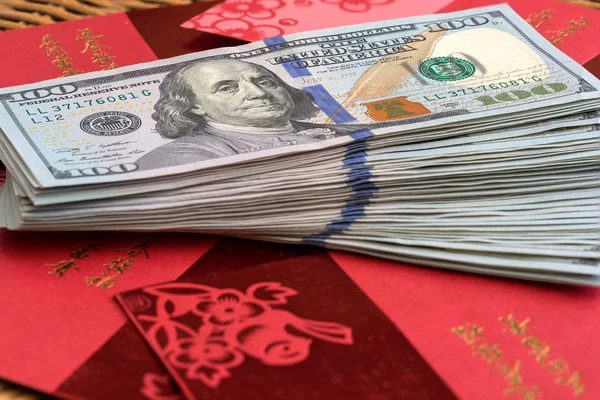 Pila di USD 100 Dollari su sfondo pacchetto rosso cinese — Foto Stock