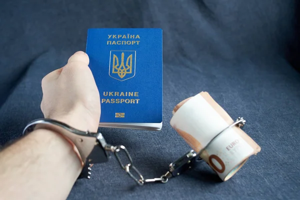 Passaporte biométrico ucraniano e algemas na mesa . — Fotografia de Stock