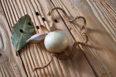 soğan, sarımsak, kara biber ve defne yaprağı ahşap arka plan üzerinde