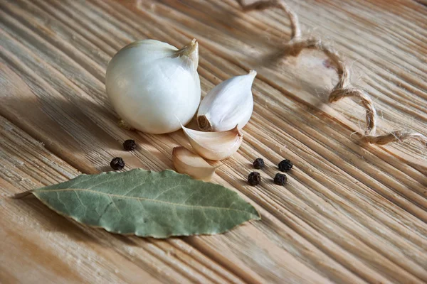 Sarımsak, soğan, defne yaprağı, karabiber ahşap bir masa üzerinde. Gıda arka plan. Sarmısakları. doğranmış sarımsak, diş sarımsak, sarımsak ampul.
