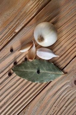 soğan, sarımsak, kara biber ve defne yaprağı ahşap arka plan üzerinde