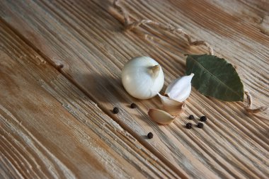 Defne yaprağı, soğan ve sarımsak ahşap masa üstüne. Kuru baharat karışımı