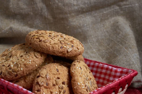 Biscotti salati cosparsi di semi di sesamo, girasole sul tavolo e fondo di iuta — Foto Stock