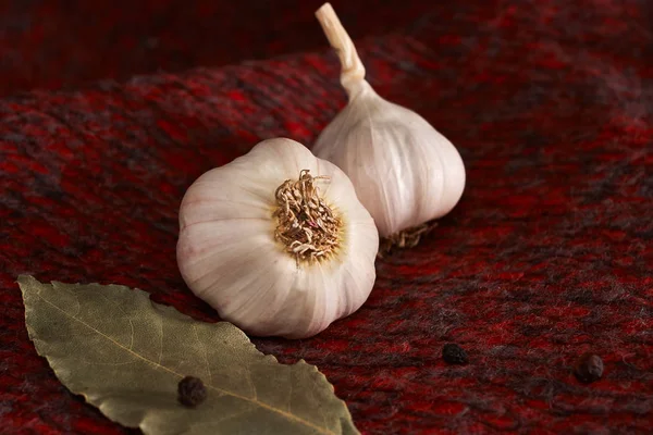 Garlic, black pepper and bayleaf on the red textile top. Dry Spices Mix