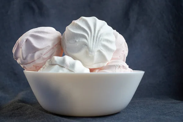 Белый и розовый зефир крупным планом на белой тарелке — стоковое фото