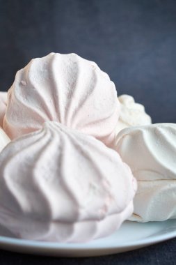 Beyaz ve pembe zephyr yakın koyu arka plan üzerinde beyaz bir plaka üzerinde çekim