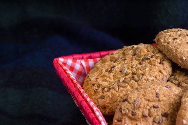 ayçiçeği tohumu ve mavi arka plan üzerinde kırmızı kareli sepet yakın ev yapımı yulaf kurabiye