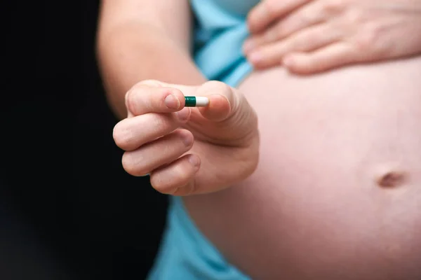 La mujer embarazada utiliza tabletas vitamínicas para una nutrición saludable. mujer embarazada utiliza vitaminas. tratamiento de las mujeres embarazadas. embarazo — Foto de Stock
