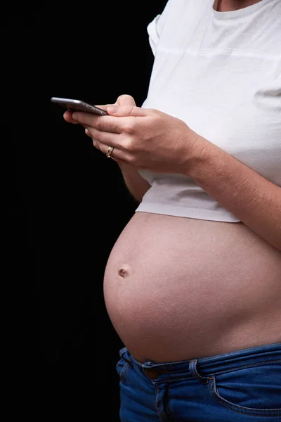hamilelik, annelik, teknoloji, insanlar ve beklenti konsepti - üzgün hamile kadın akıllı telefondan evden arıyor. Elinde telefon olan hamile bir kadın. teknoloji ve hamilelik