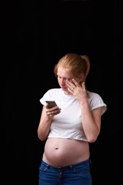 hamilelik, annelik, teknoloji, insanlar ve beklenti konsepti - üzgün hamile kadın akıllı telefondan evden arıyor. Elinde telefon olan hamile bir kadın. teknoloji ve hamilelik