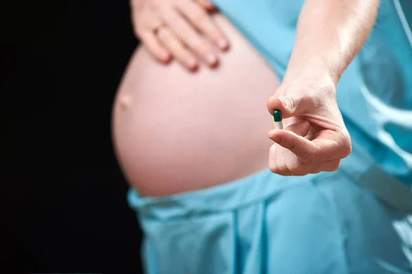 Η έγκυος γυναίκα χρησιμοποιεί δισκία βιταμινών για υγιεινή διατροφή. Η έγκυος χρησιμοποιεί βιταμίνες. θεραπεία εγκύων γυναικών. εγκυμοσύνη — Φωτογραφία Αρχείου