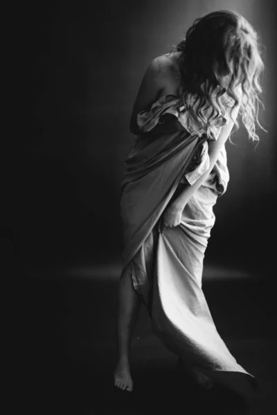 black and white studio portrait of a beautiful girl in a white sheet, beautiful female body, fashion and art