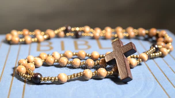 Rotation of wooden rosary on the bible. — Stock Video