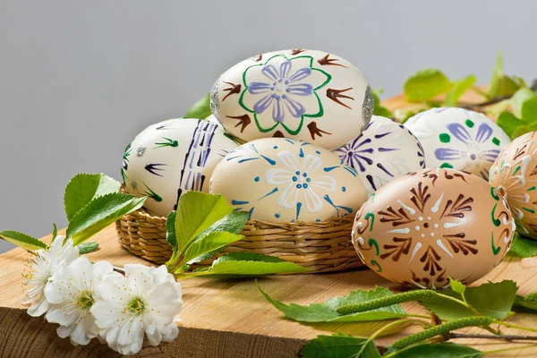 Ovos de Páscoa coloridos com flor no fundo cinza — Fotografia de Stock