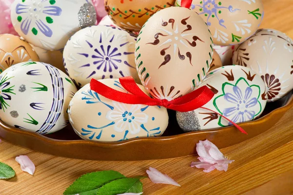 Barevné velikonoční vajíčka s květy na stůl — Stock fotografie