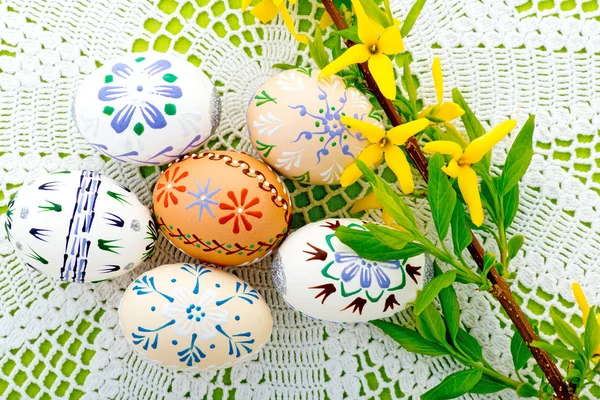 Ovos de Páscoa e flor amarela na toalha de mesa — Fotografia de Stock