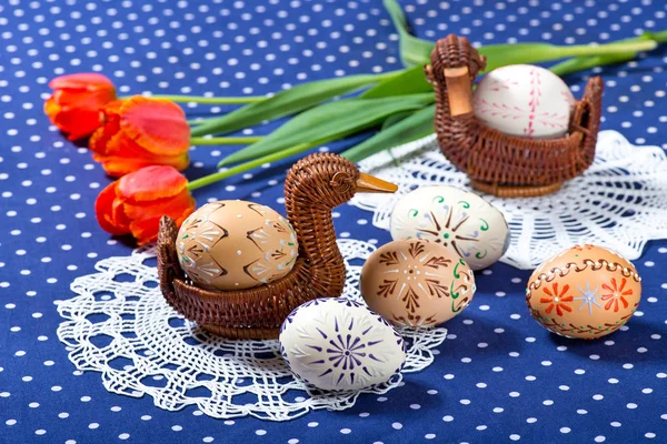イースターの卵と青のテーブル クロスの上のチューリップ — ストック写真