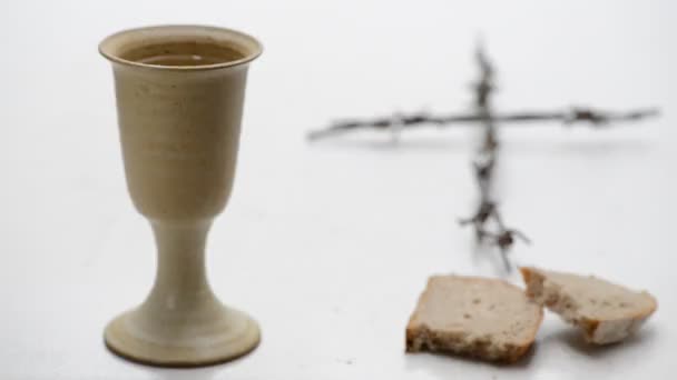 面包和耶稣受难像在麻布上的红酒的圣杯。机架焦点. — 图库视频影像