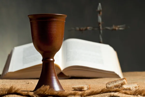 Чаша вина с хлебом и библией — стоковое фото