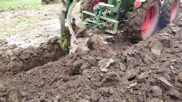 Detail van kleine trekker ploegen een veld. Geen camerabeweging. — Stockvideo