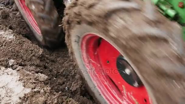 Detail eines kleinen Traktors, der ein Feld pflügt. Handschuss. — Stockvideo