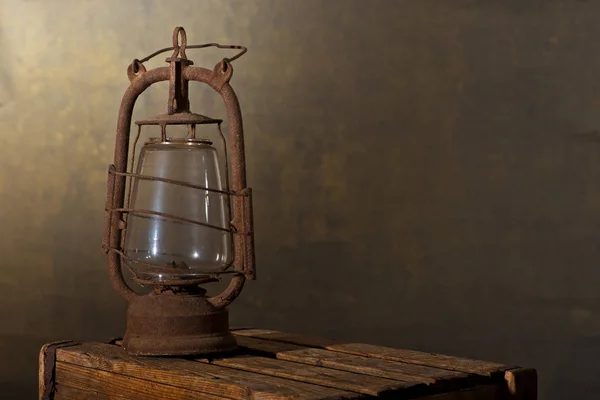 Старый ржавый фонарь на деревянном столе на чердаке — стоковое фото